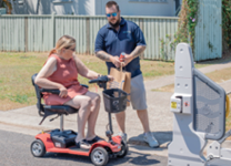 Staff assisting person using mobility scooter
