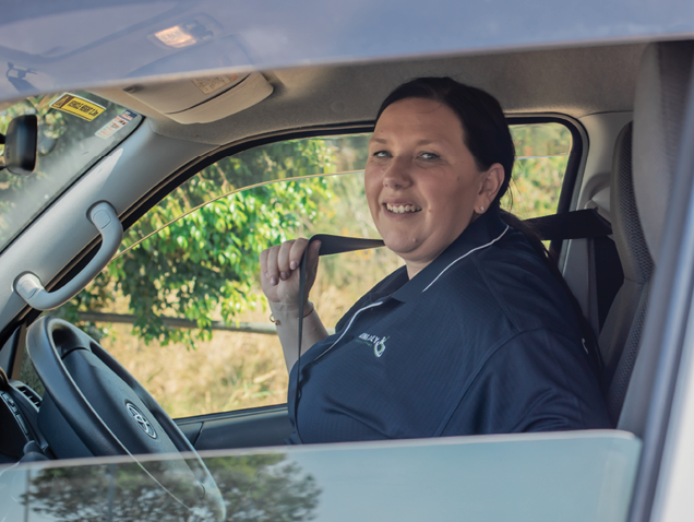 Trained mobility driver in an accessible vehicle, ready to provide safe transport across local service areas.